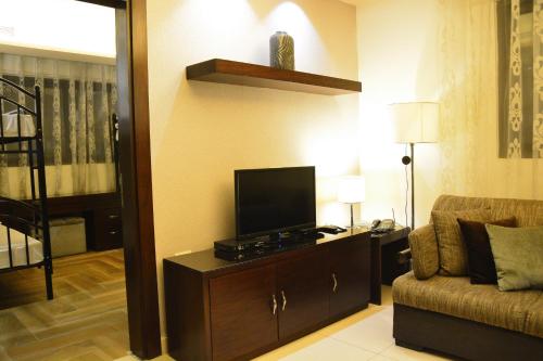 a living room with a television and a couch at Nadine Hotel Suites in Amman
