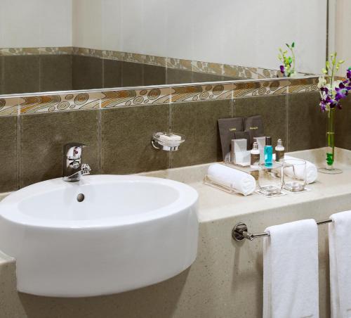 a bathroom with a white sink and a mirror at TIME Oak Hotel & Suites in Dubai