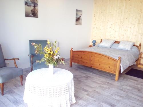 a bedroom with a bed and a table with a vase of flowers at La Forge in Sore