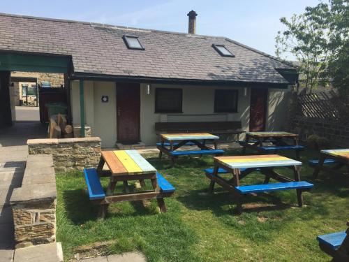 a group of picnic tables in front of a house at Market in Elsecar