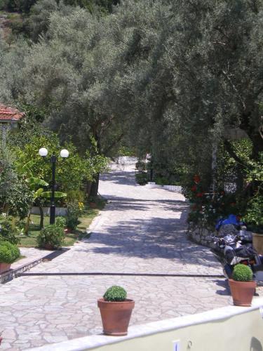 a stone path with potted plants on the side at Ilios Hotel & Villas in Yenion