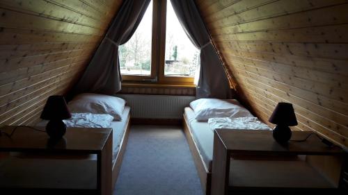 dwa łóżka w pokoju z oknem w obiekcie Eitzmanns Ferienhauser w mieście Düshorn