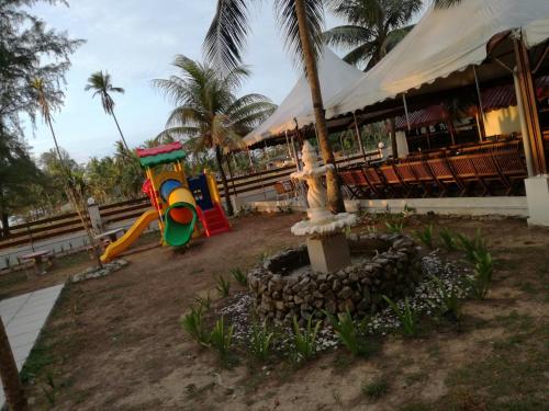 een speeltuin met een glijbaan voor een gebouw bij Al Safina Kijal Beach Resort in Kijal