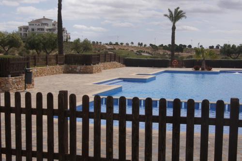 a swimming pool with a fence around it at Hacienda Requelme Golf Resort Apartment in Sucina