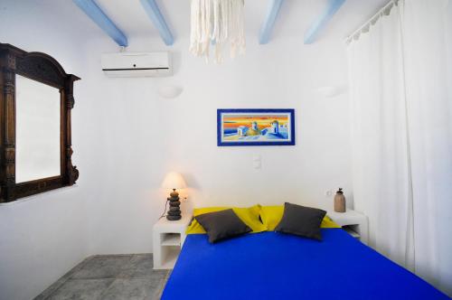 カロ・リヴァディにあるBeachfront Villa Amazing Views Mykonosのベッドルーム(青いベッド1台、鏡付)