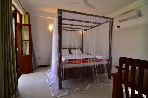 a bedroom with a canopy bed in a room at Park Lane Apartments in Negombo