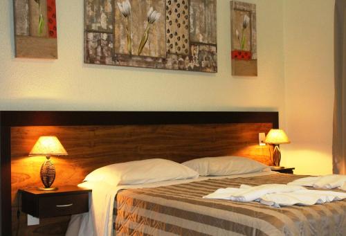 a bedroom with two beds and two lamps on tables at Villa de Holanda Parque Hotel in Holambra