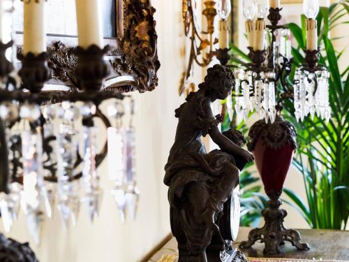 a statue of a cherub on a table next to a chandelier at Hotel Sirius in Taormina
