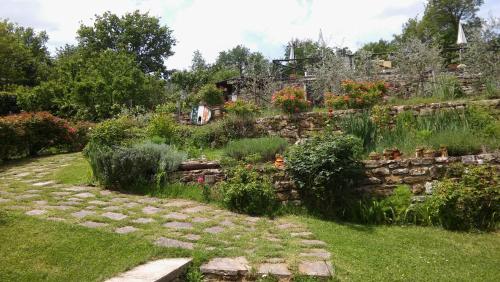a garden with a stone wall and some plants at Torre del Drago in Borgo alla Collina