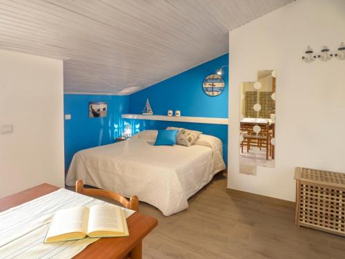 マリーナ・ディ・ラグーザにあるsiciliacasevacanze - Irideの青い壁のベッドルーム1室、ベッド1台、テーブルが備わります。