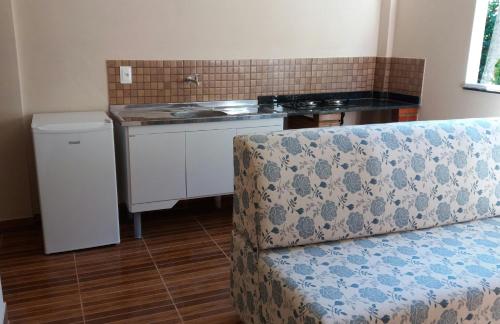 a living room with a couch and a kitchen at Flats Pedra Riscada in Lumiar