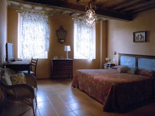 a bedroom with a bed and a desk and two windows at Agriturismo Il Gelso in Traversetolo