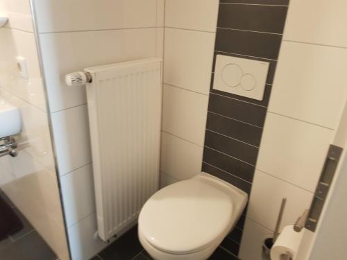 a small bathroom with a white toilet in a room at Pension Lindengarten in Nürnberg