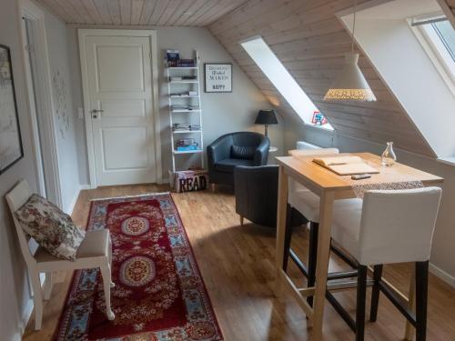 ein Wohnzimmer mit einem Tisch, Stühlen und einer Treppe in der Unterkunft Lottes Bed and Breakfast in Fårvang