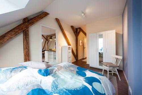 a bedroom with a blue and white comforter on a bed at Apartments LUDGERUSHOF in Bocholt