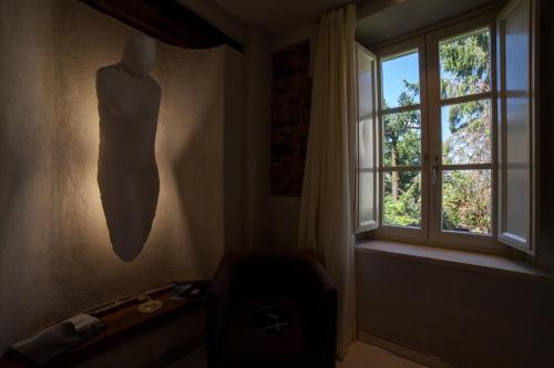 a room with a window and a dresser with a vase at Art Boutique Hotel Acchiappasogni in Barga