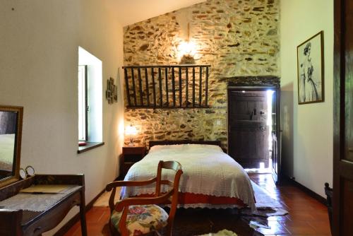 a bedroom with a bed and a stone wall at Maison d'Hôtes Léchémia in Salies-de-Béarn