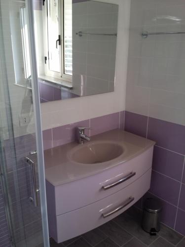 a bathroom with a sink and a mirror at Le Castella B&B Restaurant in Le Castella