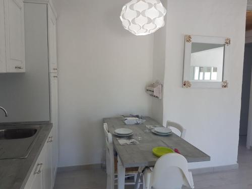 a kitchen with a wooden table with chairs and a mirror at Ca' Viscomi in San Teodoro