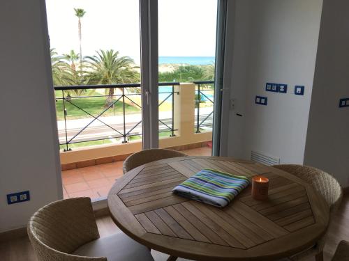 a table with a candle and chairs and a balcony at Oliva Nova Casas del Mar in Oliva