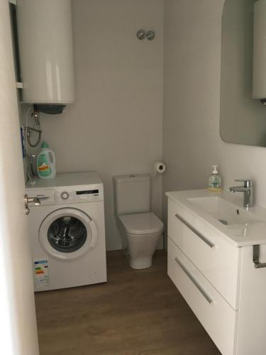 a bathroom with a washing machine and a sink at Oliva Nova Casas del Mar in Oliva