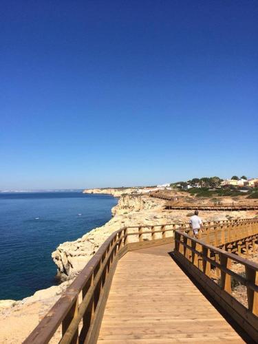 a man walking on a wooden bridge over the water at Apartamento na Praia in Carvoeiro