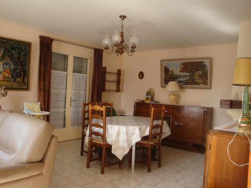 sala de estar con mesa, sillas y sofá en La Tuilerie, en Noyers-sur-Cher