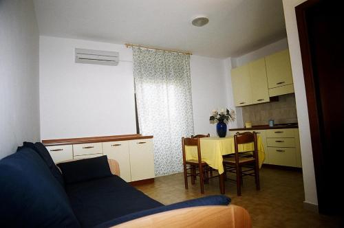 ランペドゥーザにあるVittorio Emanuele Apartmentsのリビングルーム(ソファ、テーブル、椅子付)