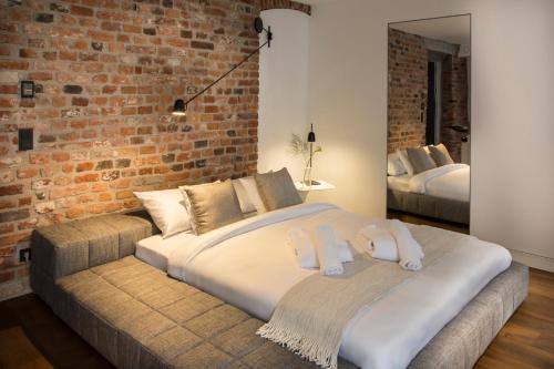 a bedroom with a large bed and a brick wall at Hotel Nicolaus in Toruń