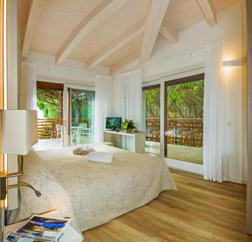 una camera con un grande letto e ampie finestre di Park Hotel Pineta & Dependance Suite a Eraclea Mare