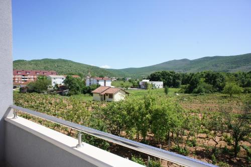 a balcony with a view of a farm and mountains at Hotel Palace Medjugorje in Međugorje