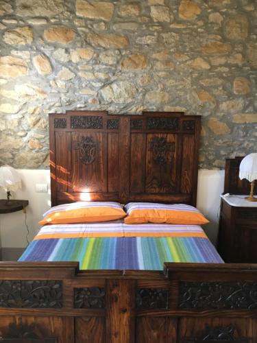 ベヴェリーノにあるCasa Guido 2- La Porta delle 5 Terreの石壁のベッドルーム1室(木製ベッド1台付)