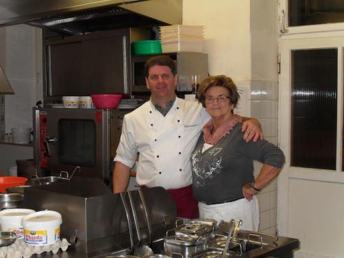 a man and a woman standing in a kitchen at Ferienhotel Barmsee in Krün