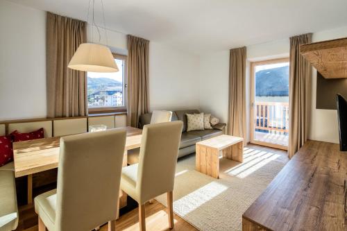 a living room with a dining table and a couch at hubertus dolomites in Fiè