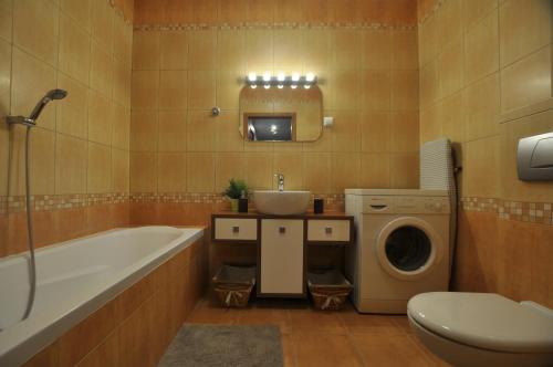 ワルシャワにあるFieldorfa Apartmentのバスルーム(バスタブ、シンク、洗濯機付)