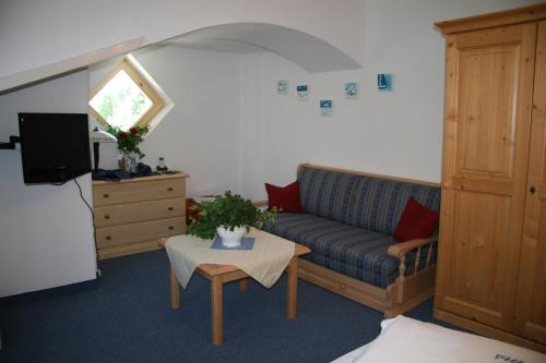 a living room with a couch and a table at Ferienhotel Barmsee in Krün