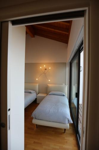 a bedroom with two beds and a window at Casa Vigole in Toscolano Maderno