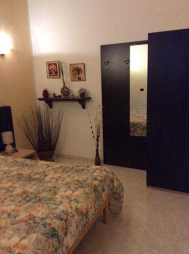 a bedroom with a bed and a door with a mirror at Alloggio privato Giunic in Cagliari