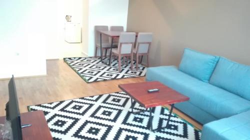 a living room with a blue couch and a table at Modern Living Apartments in Skopje