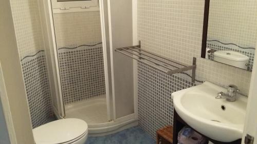 een badkamer met een toilet, een wastafel en een douche bij Vista Mar Apartment in L'Ampolla