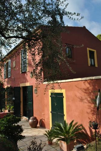 a red building with a green door in front of it at Sous L'Olivier in Menton