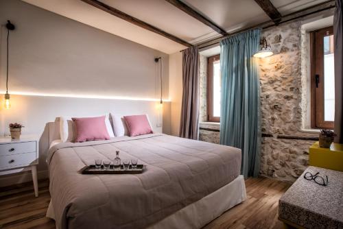 a bedroom with a large bed with pink pillows at Veneziano Boutique Hotel in Heraklio