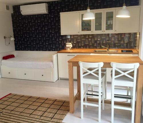 a kitchen with a table and two white stools at Apartamenty Flaming Baltic Park Stegna in Stegna