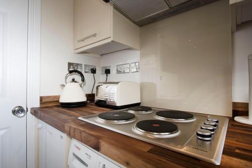 a kitchen with a stove top and a toaster oven at The Grapevine Studio in Cambridge