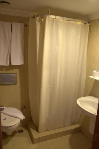 a bathroom with a shower curtain and a toilet at Surtel Hotel in Kusadası