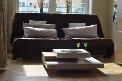 un sofá con almohadas y una mesa en la sala de estar. en All-in-One, en Berlín