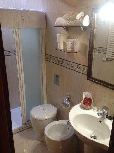 a bathroom with a sink and a toilet and a mirror at La Posada del Rey in Llanes