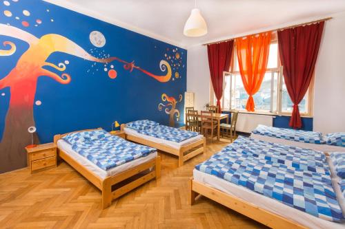 Habitación con 3 camas y un mural en la pared. en Hostel Downtown, en Praga