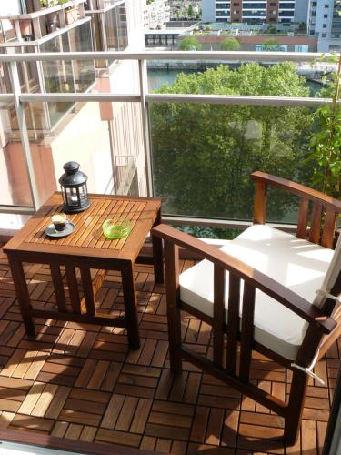 d'une table et d'une chaise en bois sur un balcon avec vue. dans l'établissement Studio Belle Vue, à Strasbourg