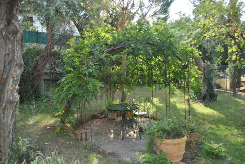 a small garden with a table and some plants at Sous L'Olivier in Menton